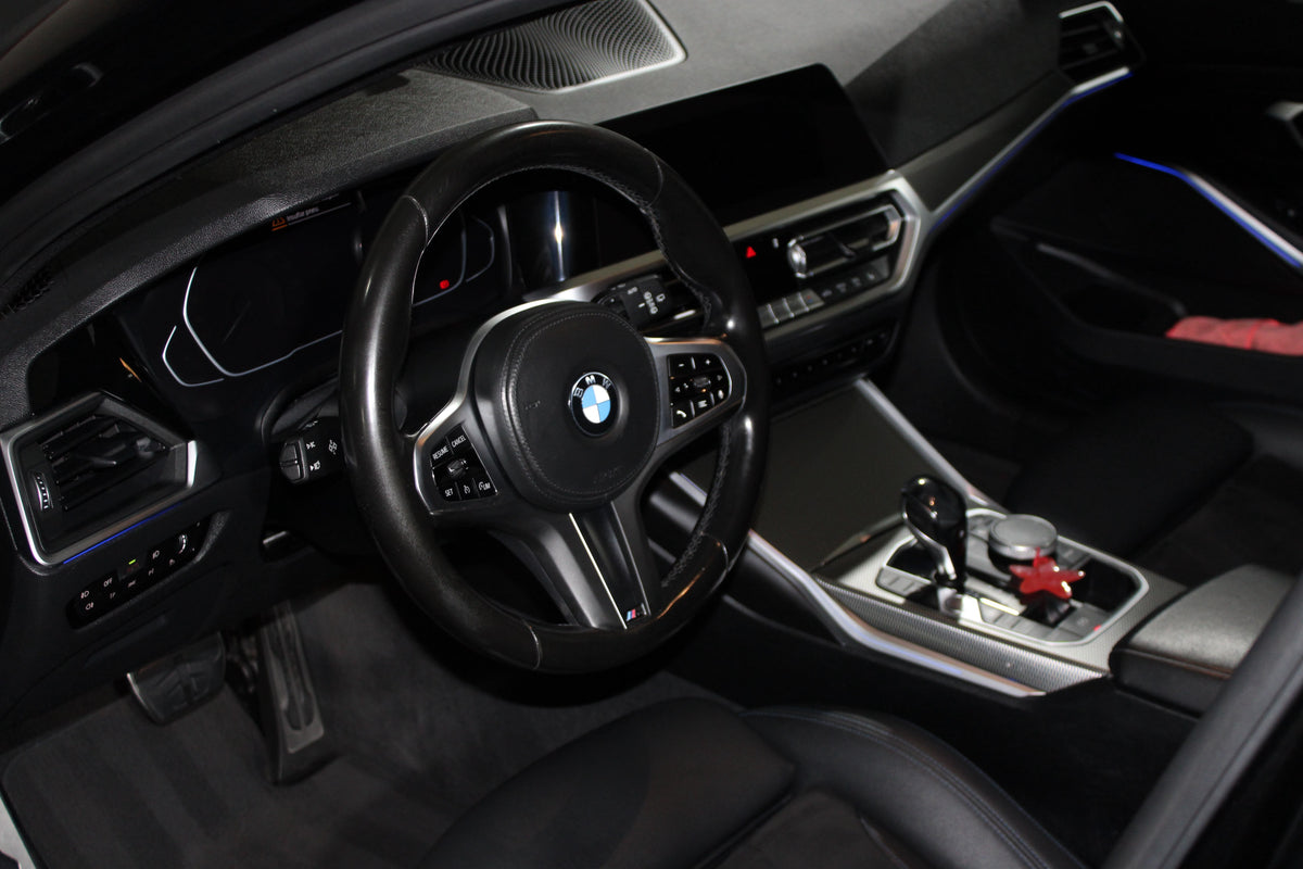 Interior de um BMW, com volante, painel e consola central em destaque